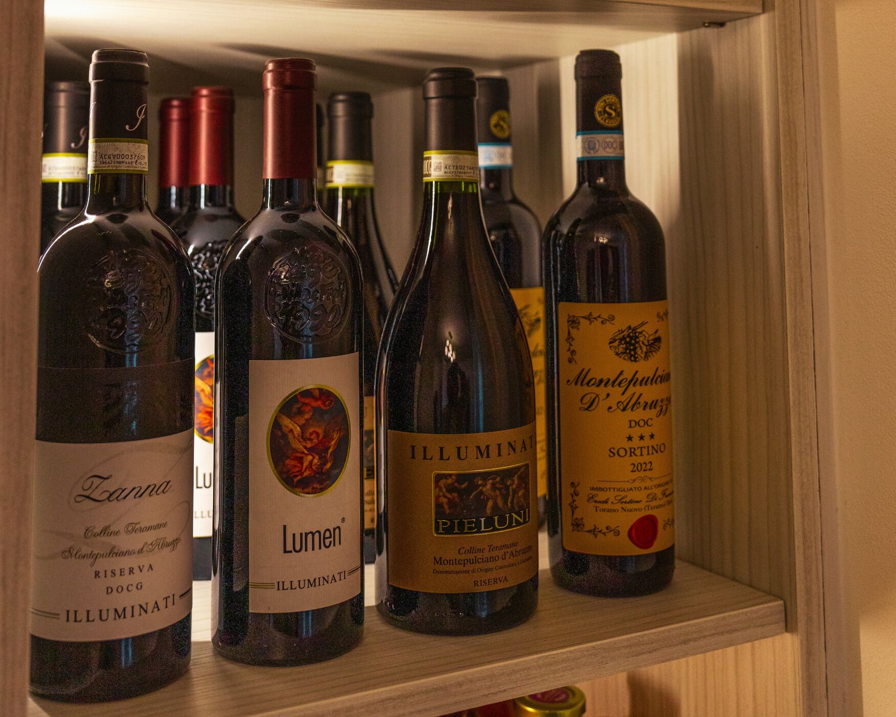 A wine rack with bottles of Illuminati and Montepulciano D'Abruzzo DOC wines.