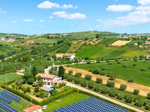 Un paysage rural avec des maisons, des panneaux solaires et des collines ondulantes.