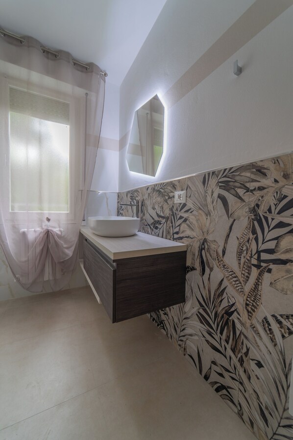 A bathroom with a white sink, a mirror, and a window with sheer curtains. - Villa Yucca - B&B and Glamping (Torano Nuovo)