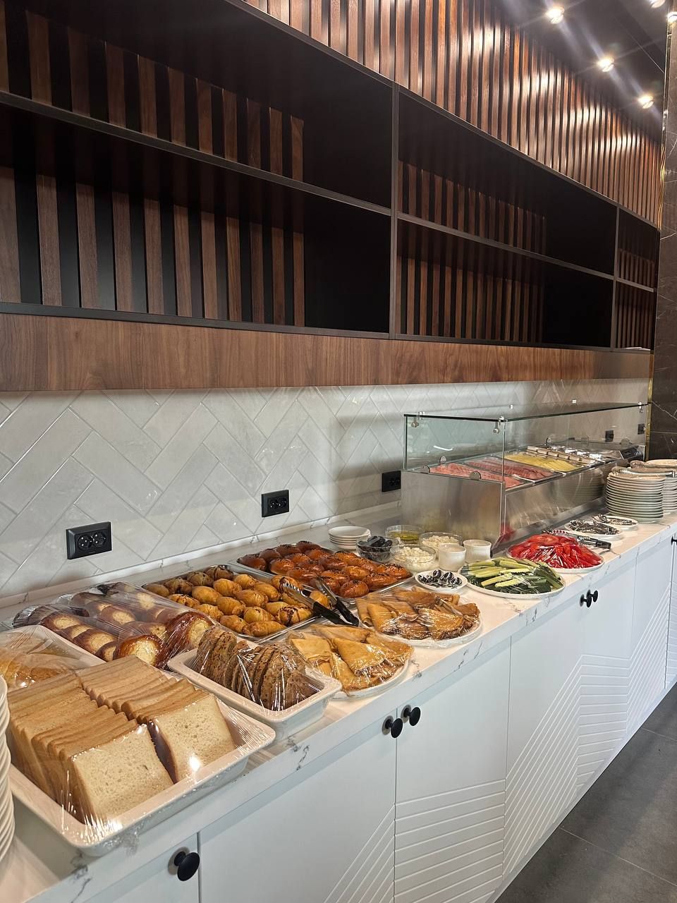 A buffet with various food items and a modern interior design.