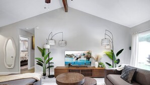 A modern living room with a TV, sofa, and coffee table.