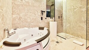 Une salle de bain moderne avec une baignoire sur pieds, une douche à parois de verre et des murs en marbre.
