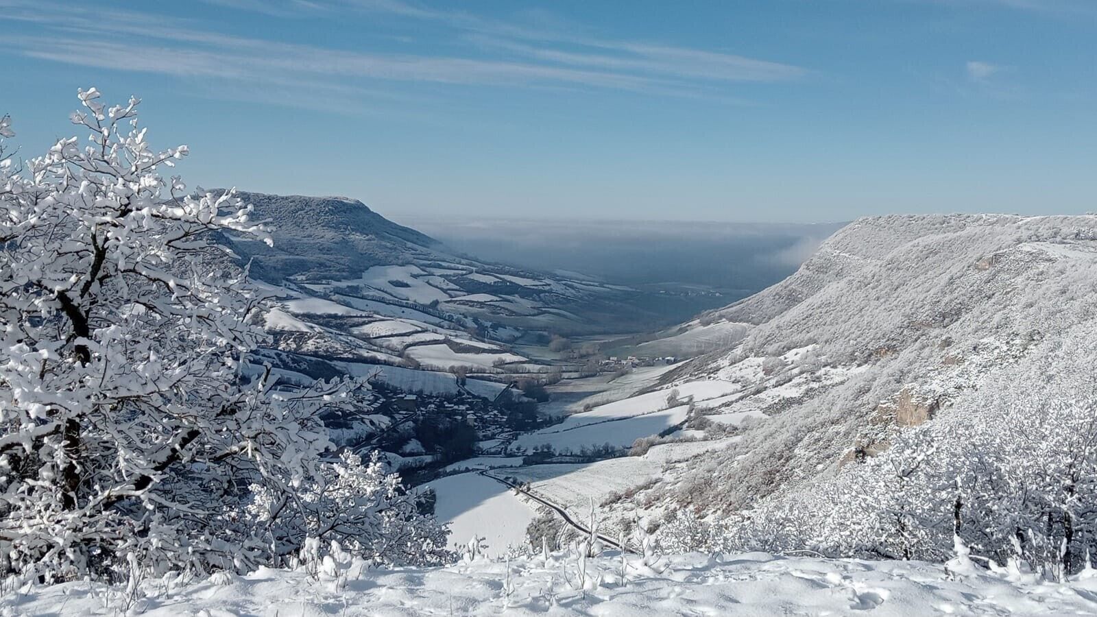 A snow-covered valley with a clear sky.
