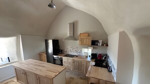 Une cuisine dotée d’un îlot central, de meubles en bois, d’un four à micro-ondes et d’une cuisinière.