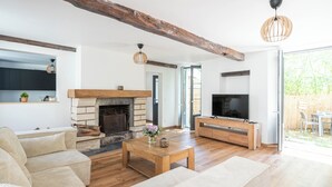 A spacious living room with a fireplace, wooden furniture, and a TV. - Beautiful family house sleeps 9 near the castle in Dampierre (Dampierre-en-Yvelines)