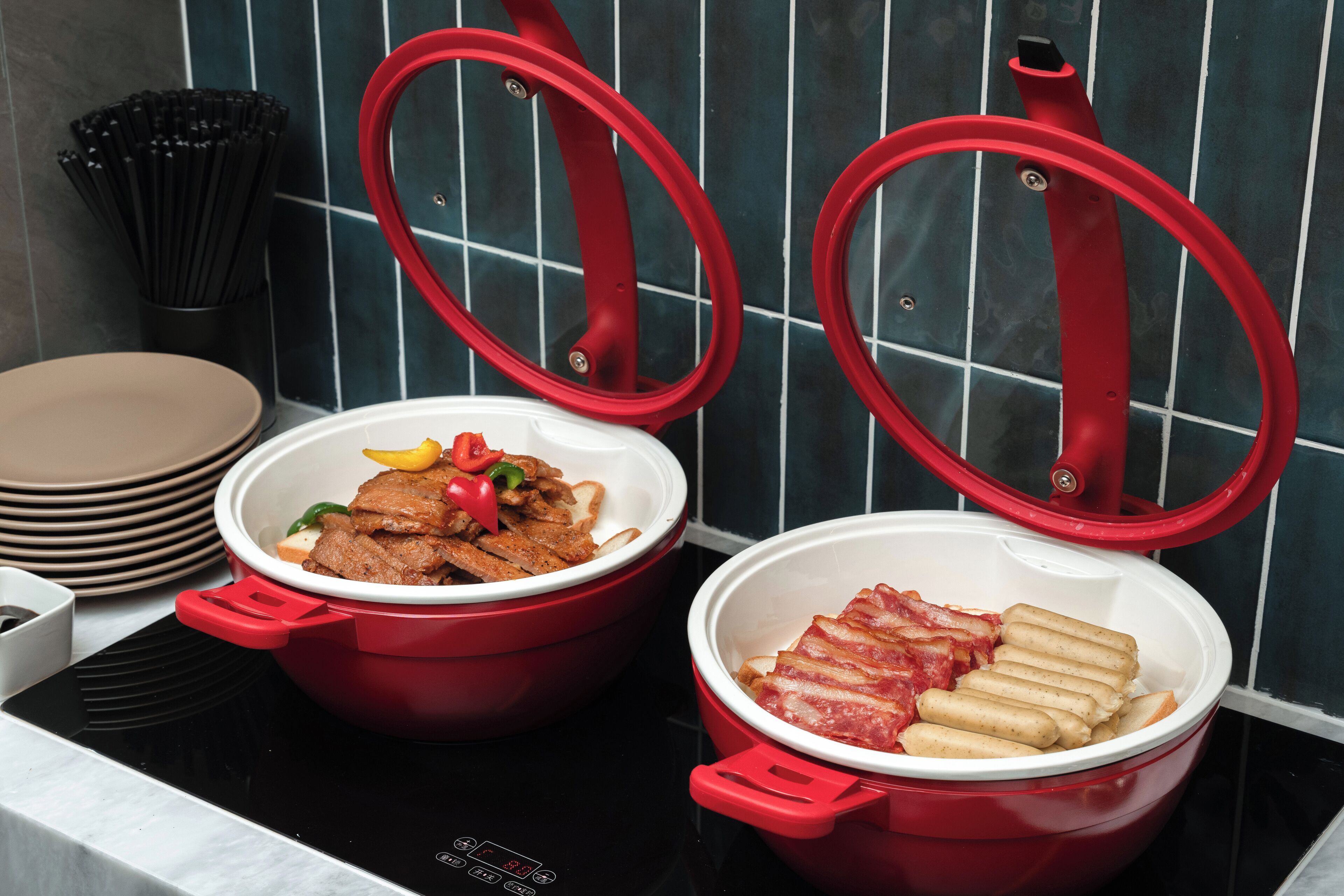 Two red pots on a stove with lids, containing food.