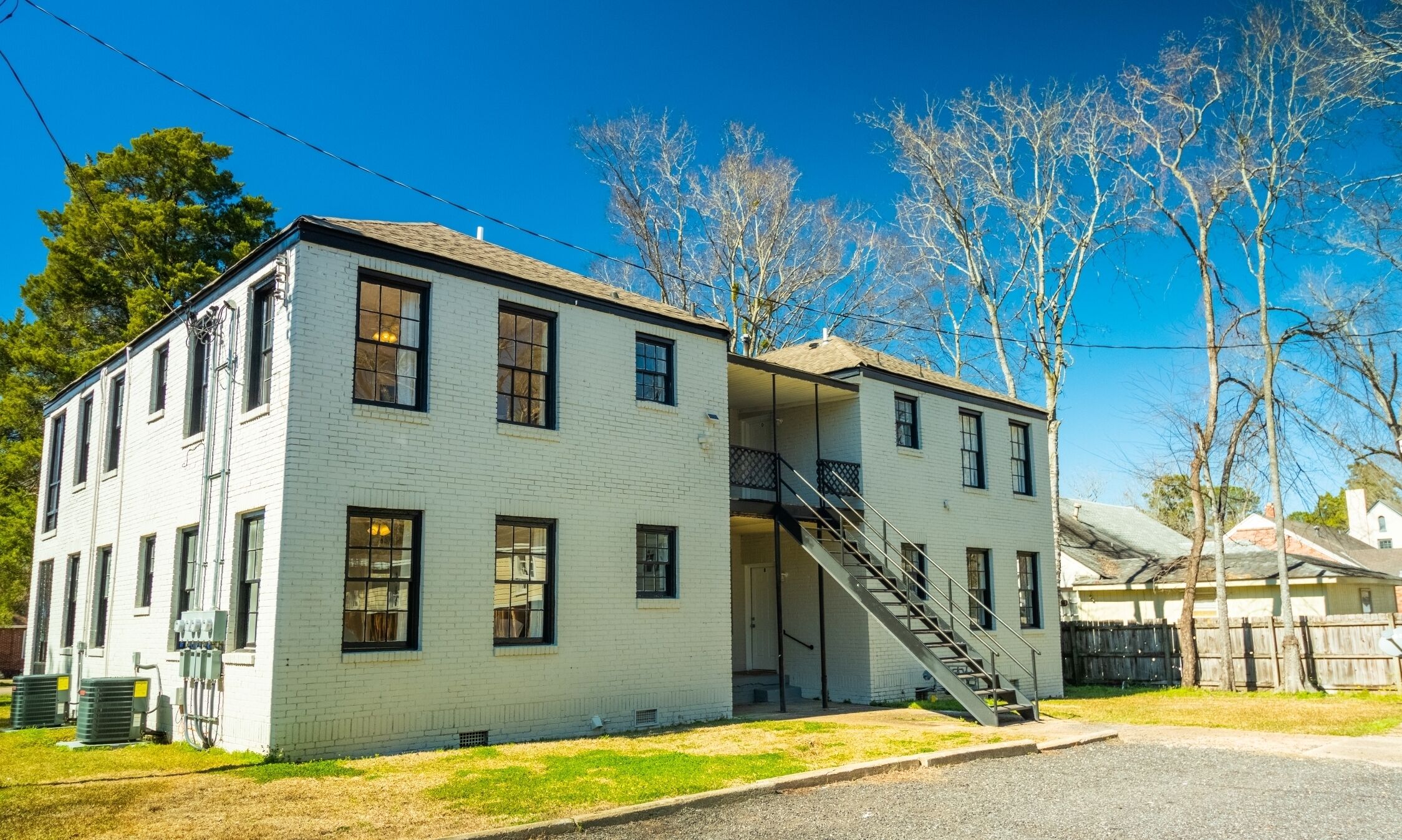 A two-story white building with a central staircase and a small porch.