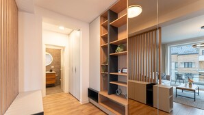 A modern interior with a wooden floor, a built-in bookshelf, and a dining area with a table and chairs. - MoHost - Uno (Brasov)