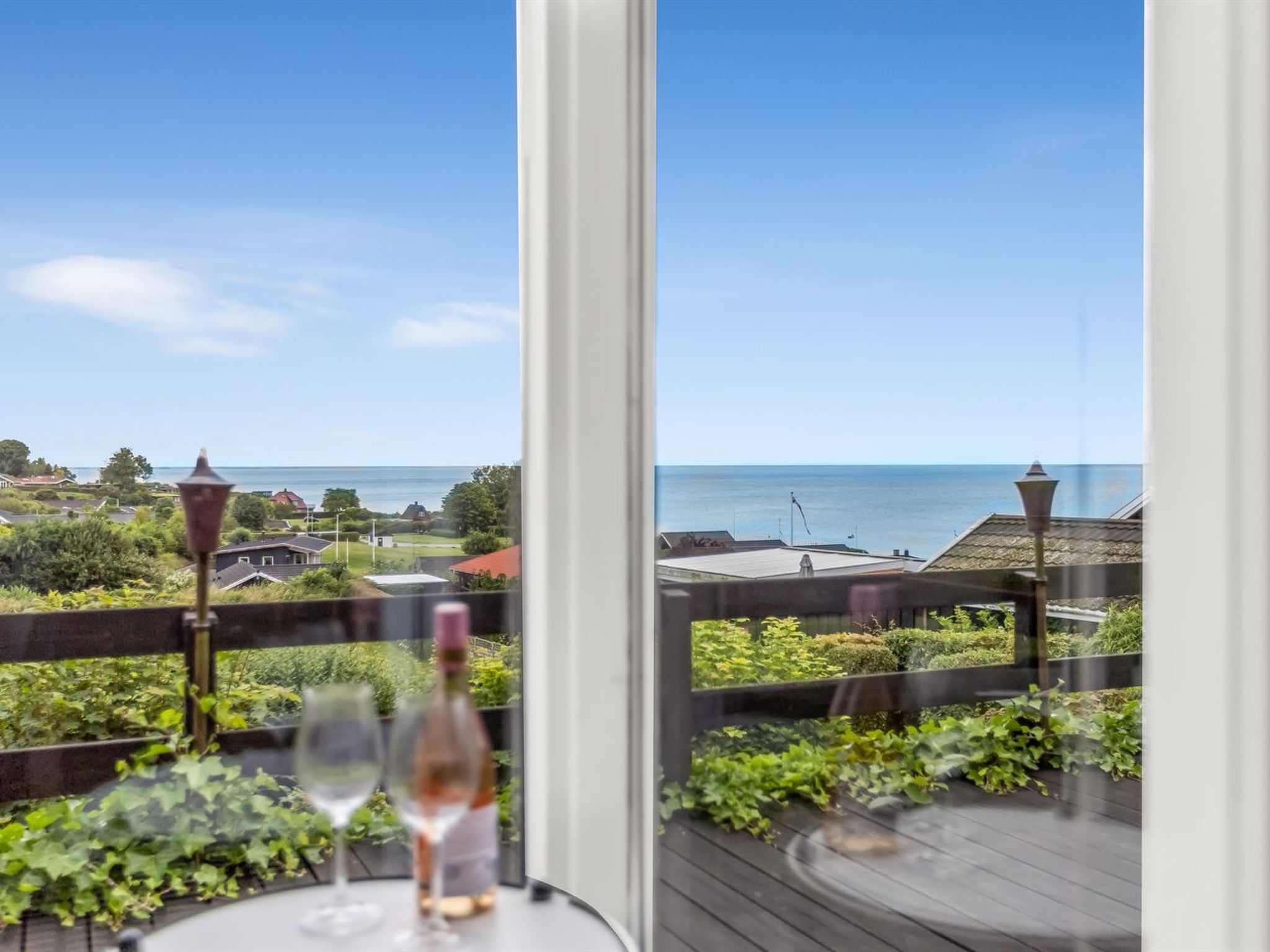 A balcony with a view of the sea and houses.