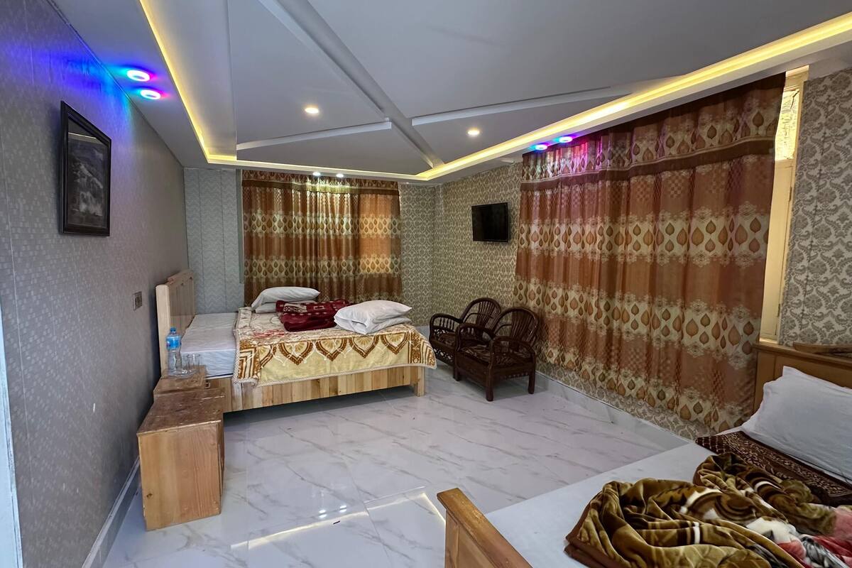 A bedroom with a bed, bedside table, and a wooden chair.