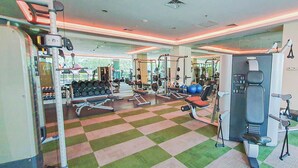 A gym with various exercise equipment, a checkered floor, and a large mirror.