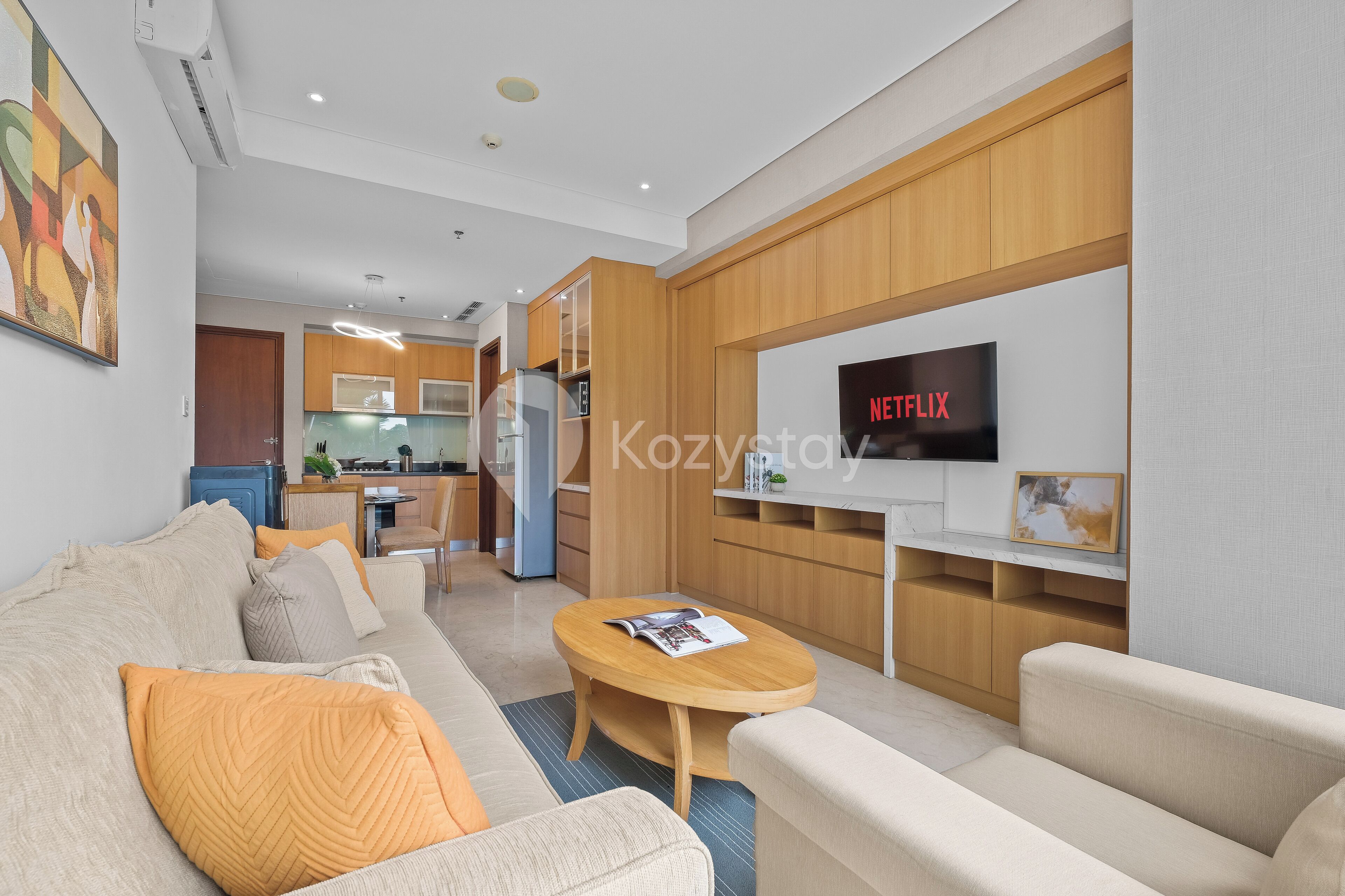 A modern living room with a sofa, coffee table, and a flat-screen TV mounted on the wall.