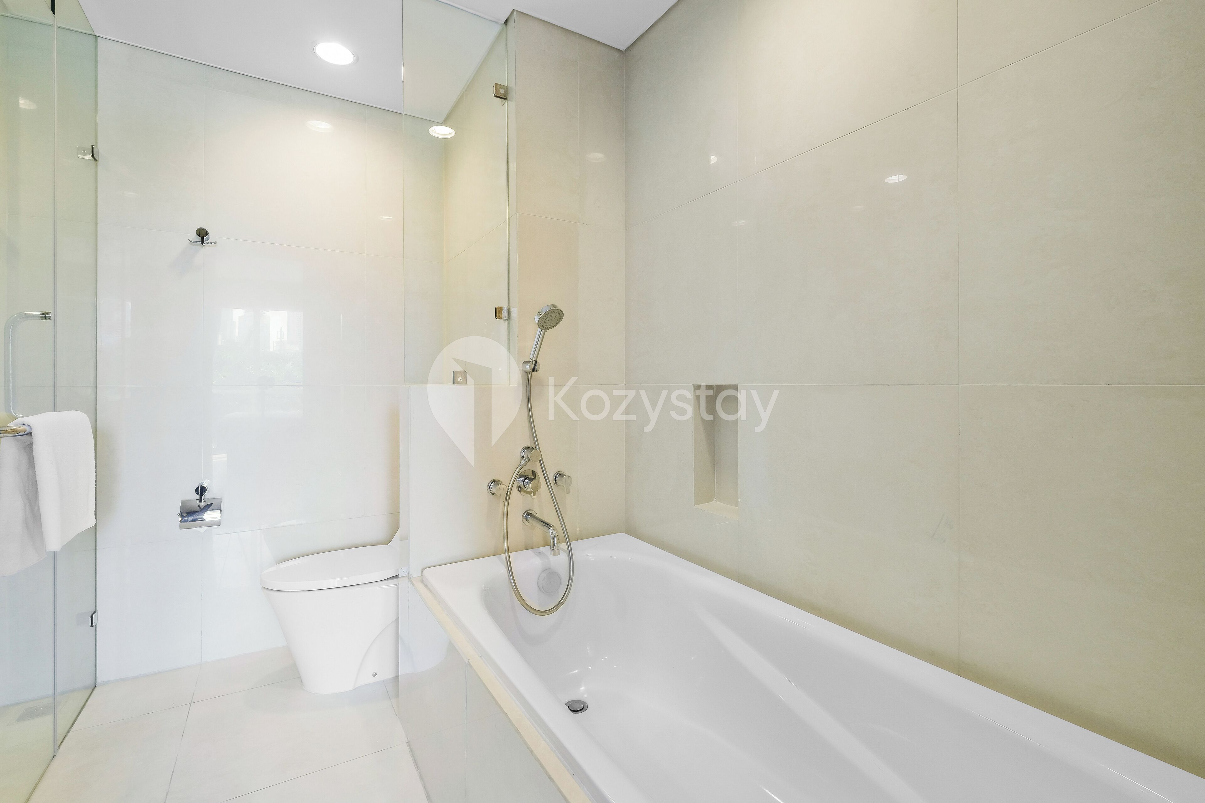Un baño moderno con ducha envuelta en vidrio, una bañera blanca y un inodoro.
