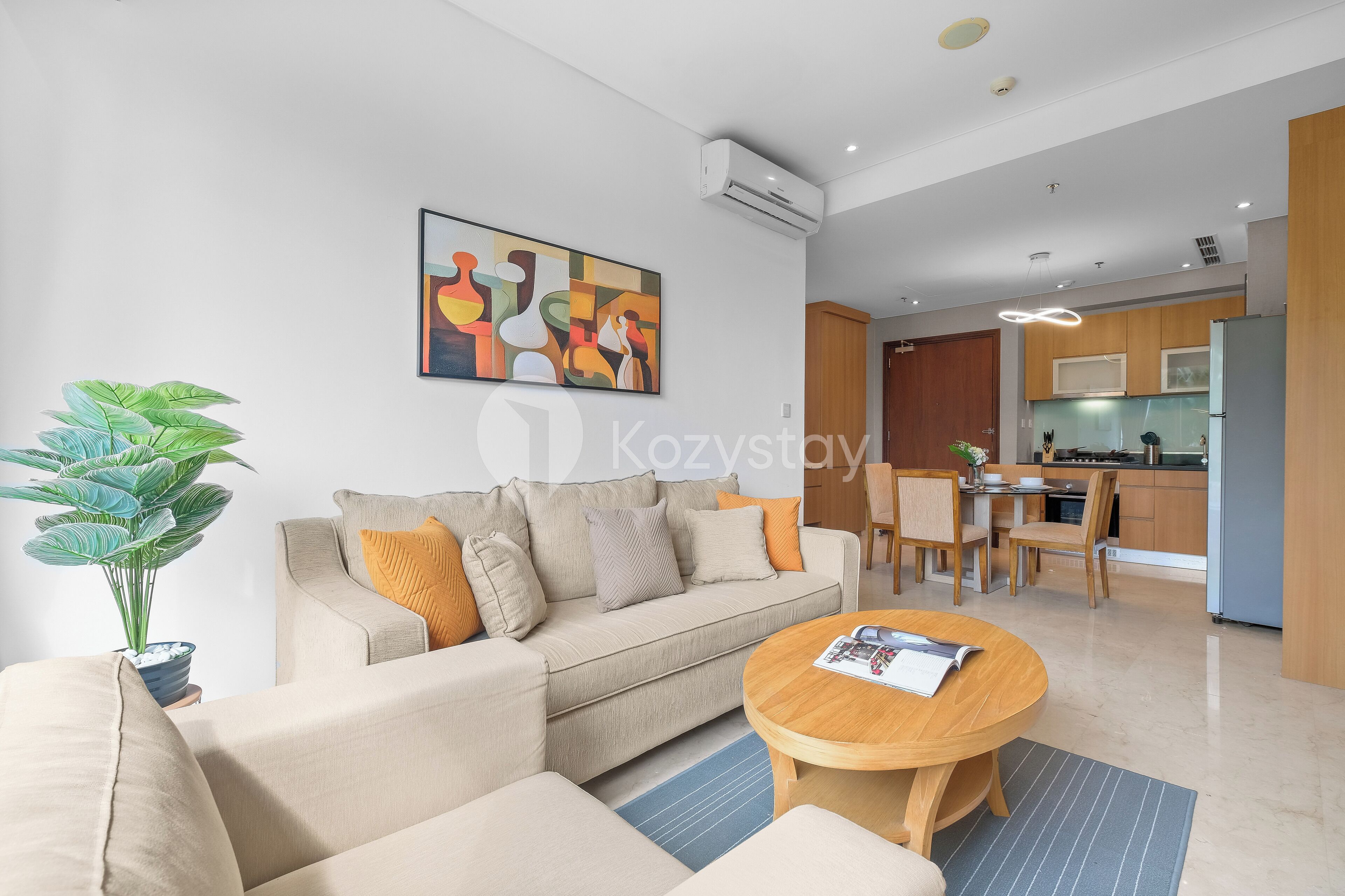 A modern living room with a beige sofa, a coffee table, and a large abstract painting.