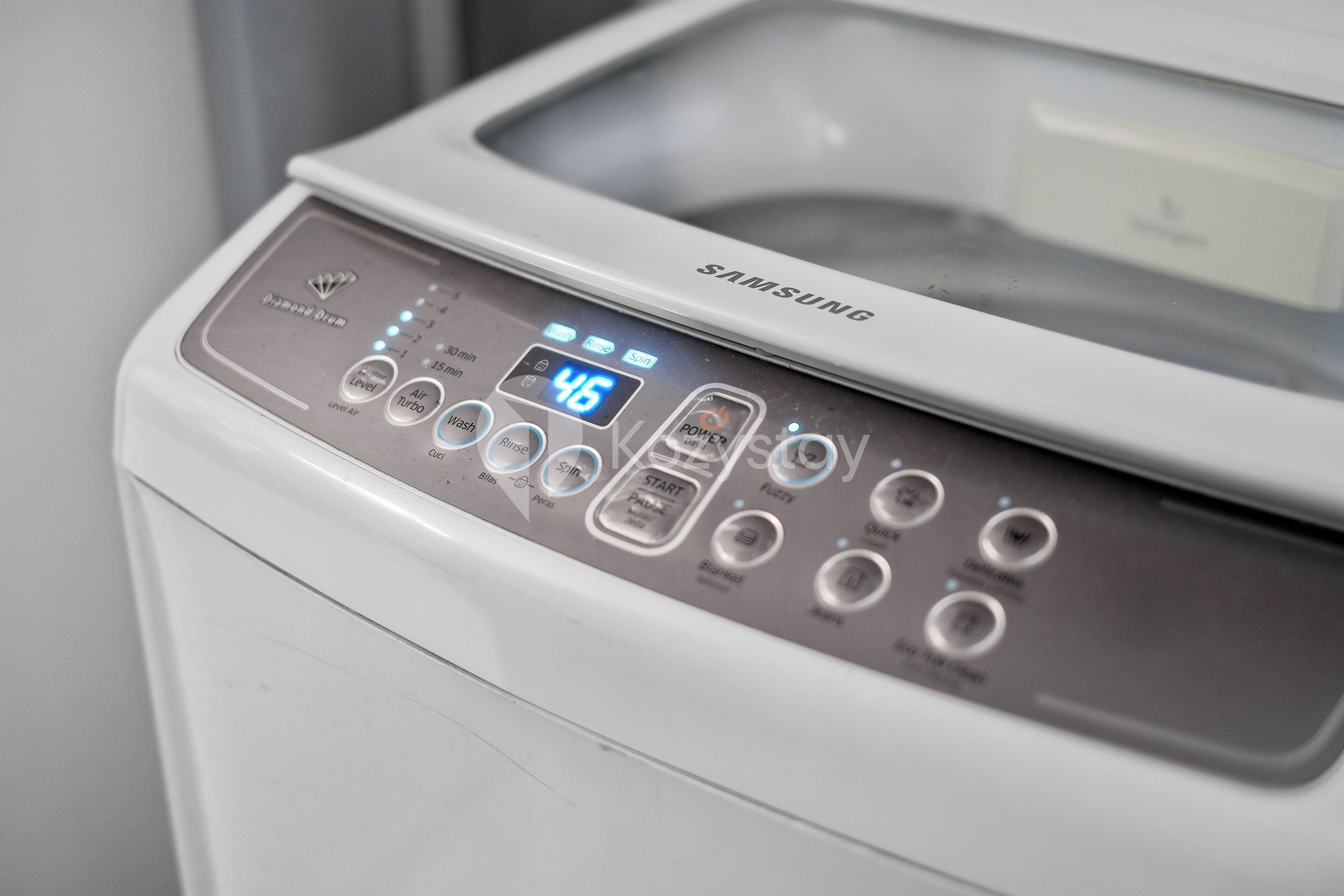 A Samsung washing machine with a digital display, multiple control buttons, and a transparent door.