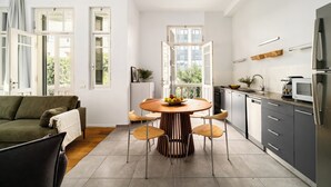 Eine moderne Küche mit Essbereich, ausgestattet mit einem Holztisch, Stühlen und einer Obstschale.