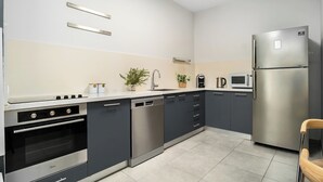 Eine moderne Küche mit Geschirrspüler, Backofen, Mikrowelle und Kühlschrank.