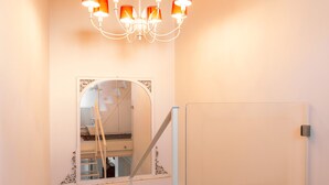 A staircase with a glass railing, a white door, and a chandelier with orange lampshades. - Large Sunny Apartment in Verona - Sleeps 8 - Easy Free Parking (Parona)