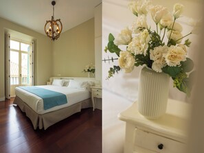 A bedroom with a bed, bedside tables, a nightstand, a chandelier, and a window with a view. - Madeinterranea Apartments  (Málaga)