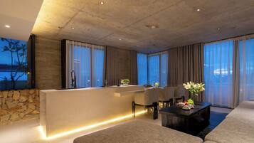 A modern living room with a stone accent wall, a central island with a sink, and a seating area with a coffee table.
