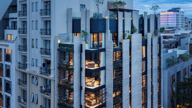 Un moderno edificio de gran altura con varios balcones y un atrium central.