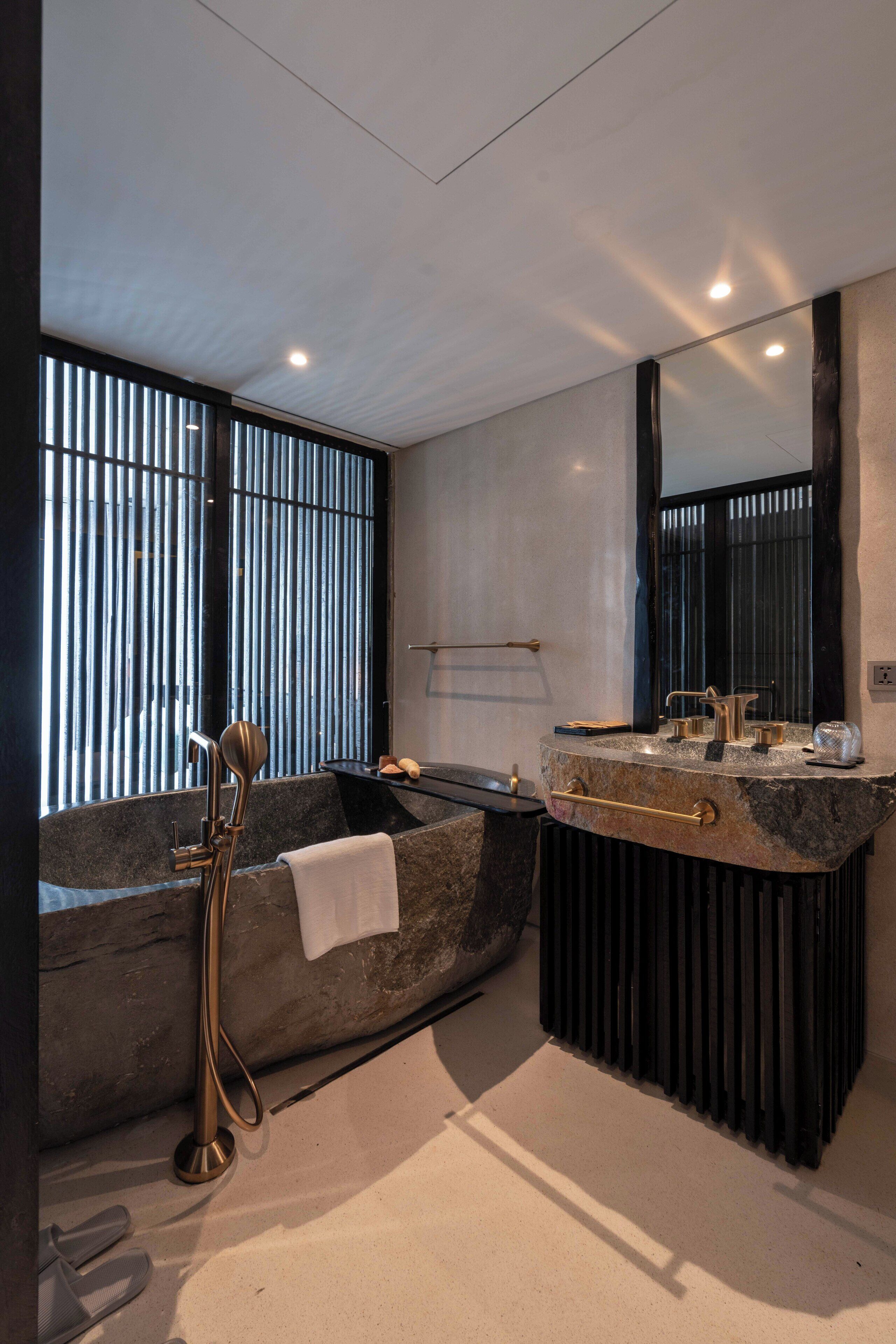 Une salle de bain moderne avec une baignoire sur pieds, un meuble-lavabo avec un miroir et un porte-serviettes.