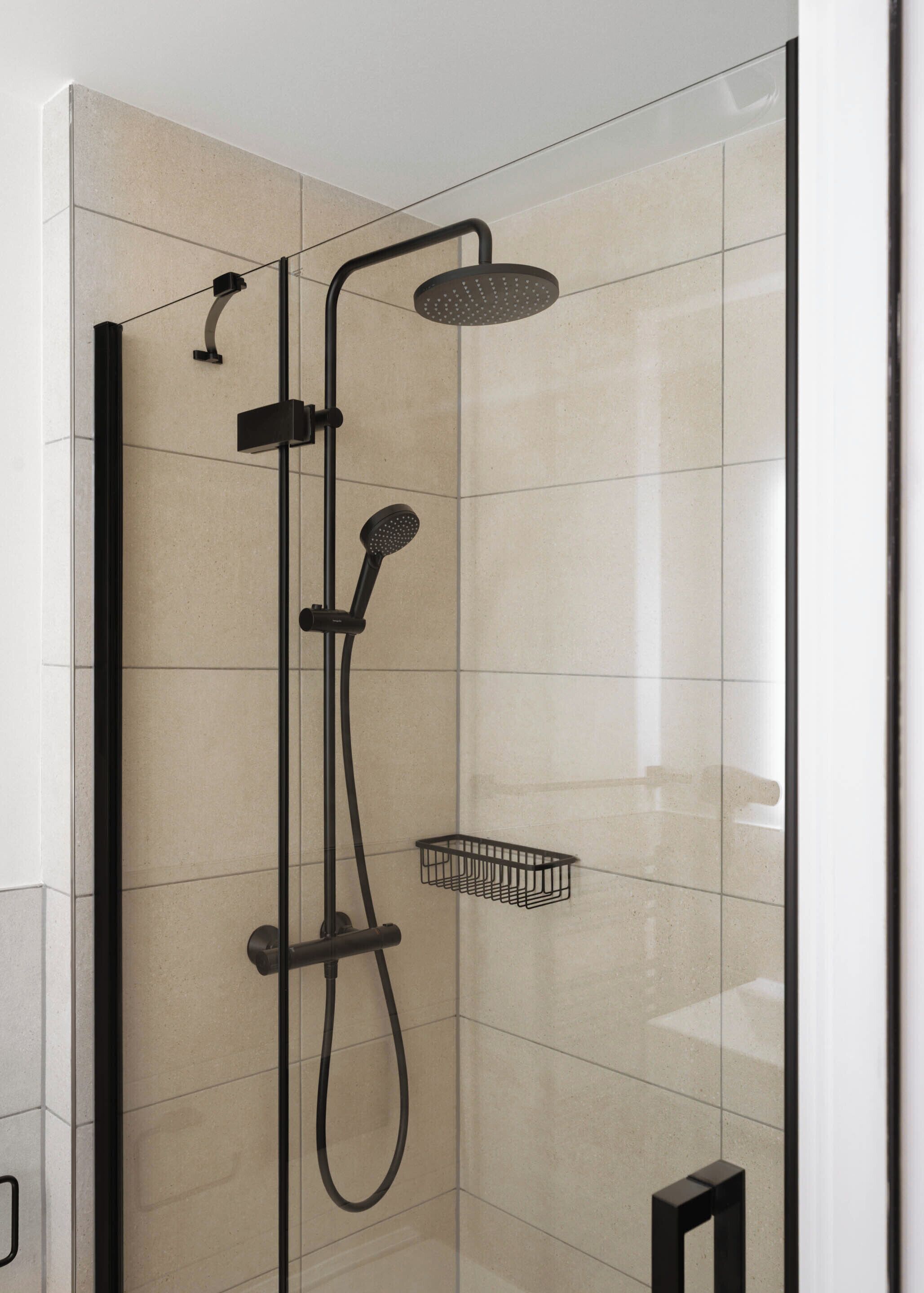 Een moderne douchecabine met een handdouche, een douchekop en een handdouche met een regenkop.