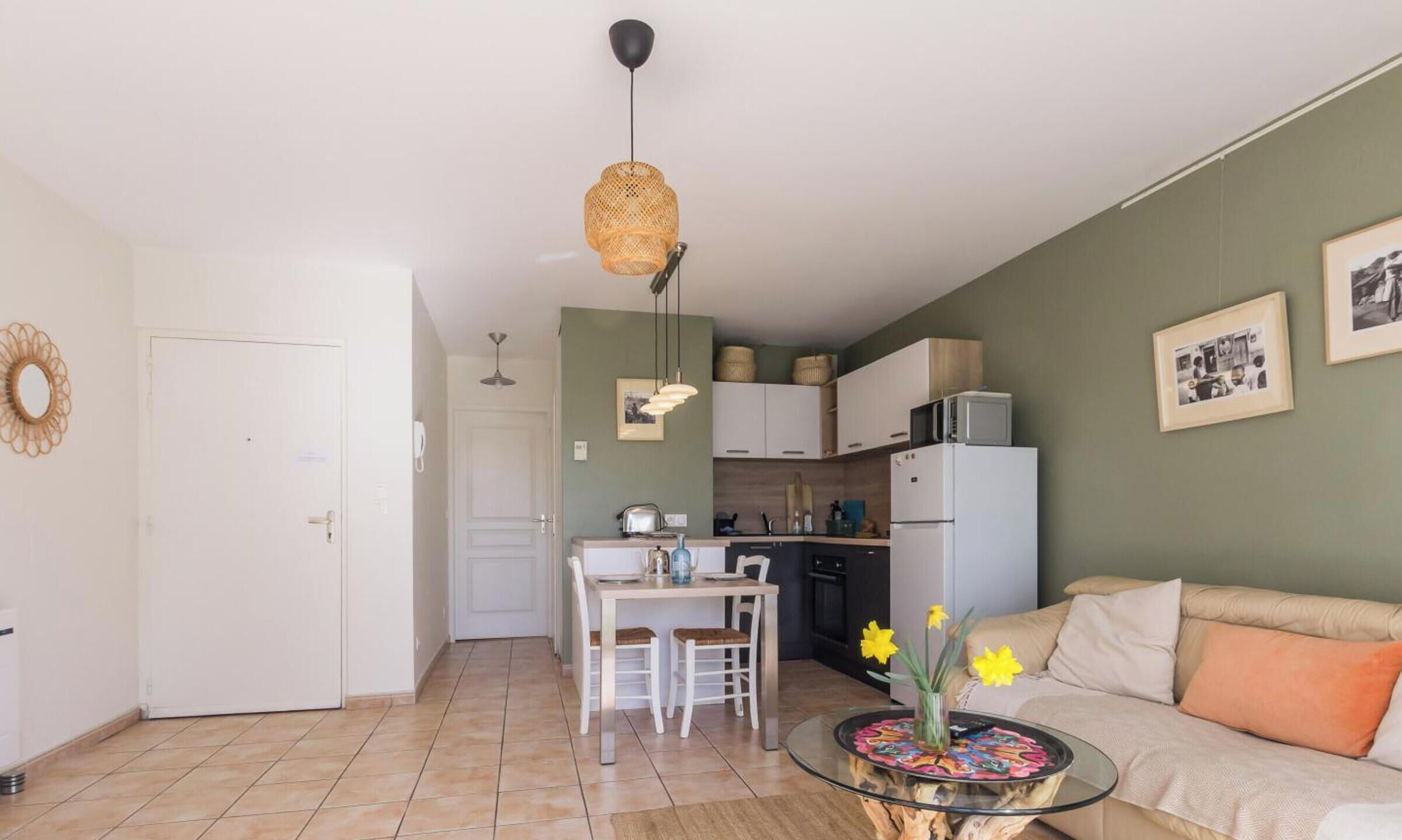 A compact living space with a dining area, kitchenette, and a sofa.