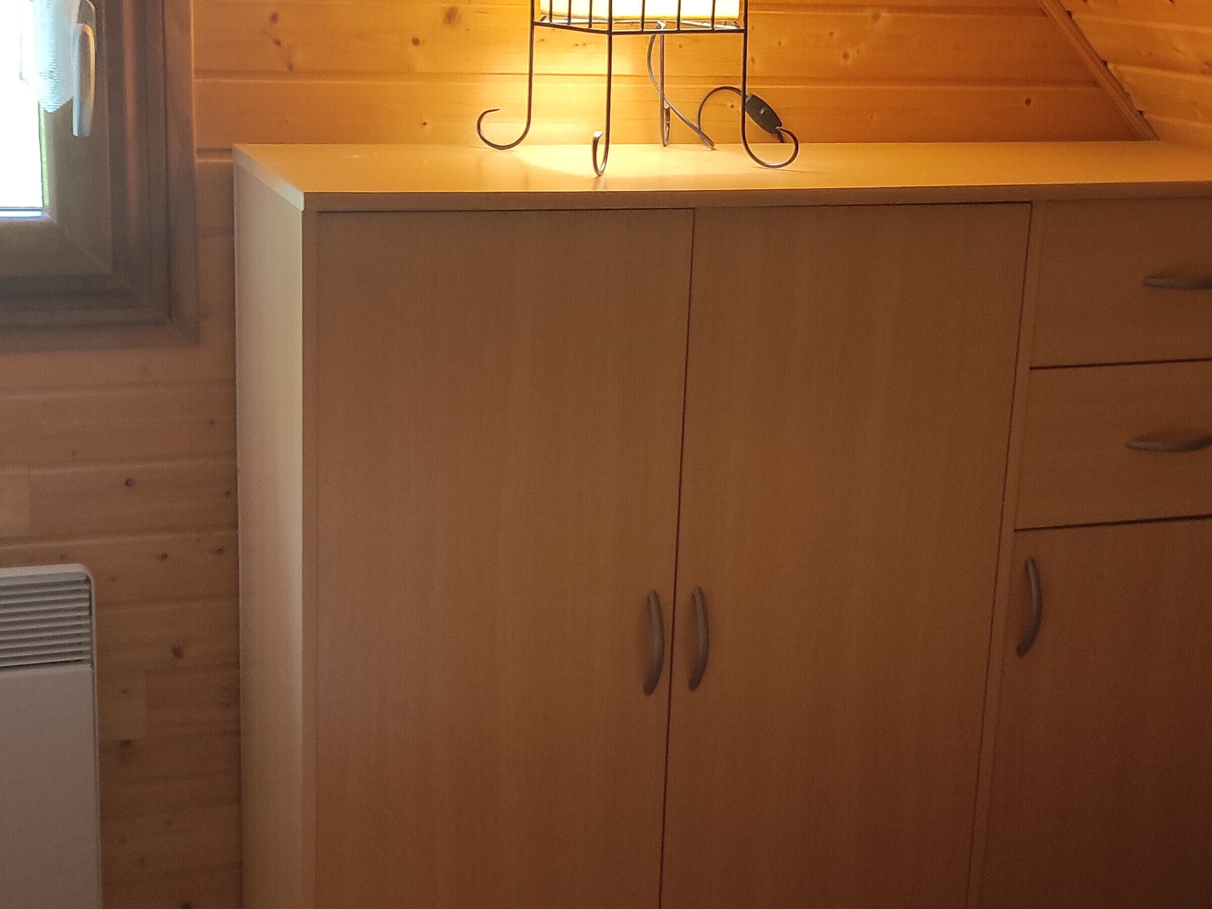 Un meuble en bois doté de deux portes et d’un plan de travail sur le dessus.