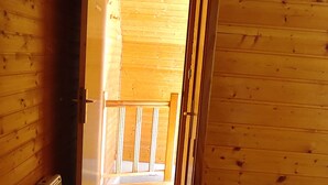 Een houten interieur met een gang die uitkomt op een balkon.