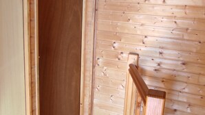 Een houten trap met een leuning die naar een hoger gelegen verdieping leidt.