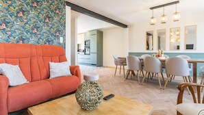 Una sala de estar moderna con sofá, mesa de centro y comedor.