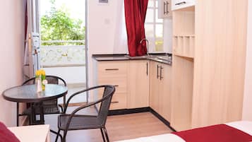 Departamento Deluxe, vista a la ciudad | Cocina privada | Refrigerador, microondas y utensilios de cocina