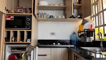 Departamento Deluxe, vista a la ciudad | Cocina privada | Refrigerador, microondas y utensilios de cocina