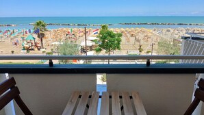 A balcony with a view of a beach, featuring a wooden table and chairs. -  RN003 - Torre Pedrera, exclusive three-room apartment facing the sea with a balcony (Torre Pedrera)