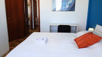 Una habitación de hotel con una cama, un escritorio, una silla y un cuadro en la pared.
