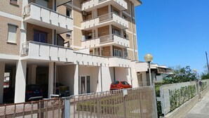 A multi-story residential building with balconies, a parking area, and a gated entrance. -  RN003 - Torre Pedrera, exclusive three-room apartment facing the sea with a balcony (Torre Pedrera)