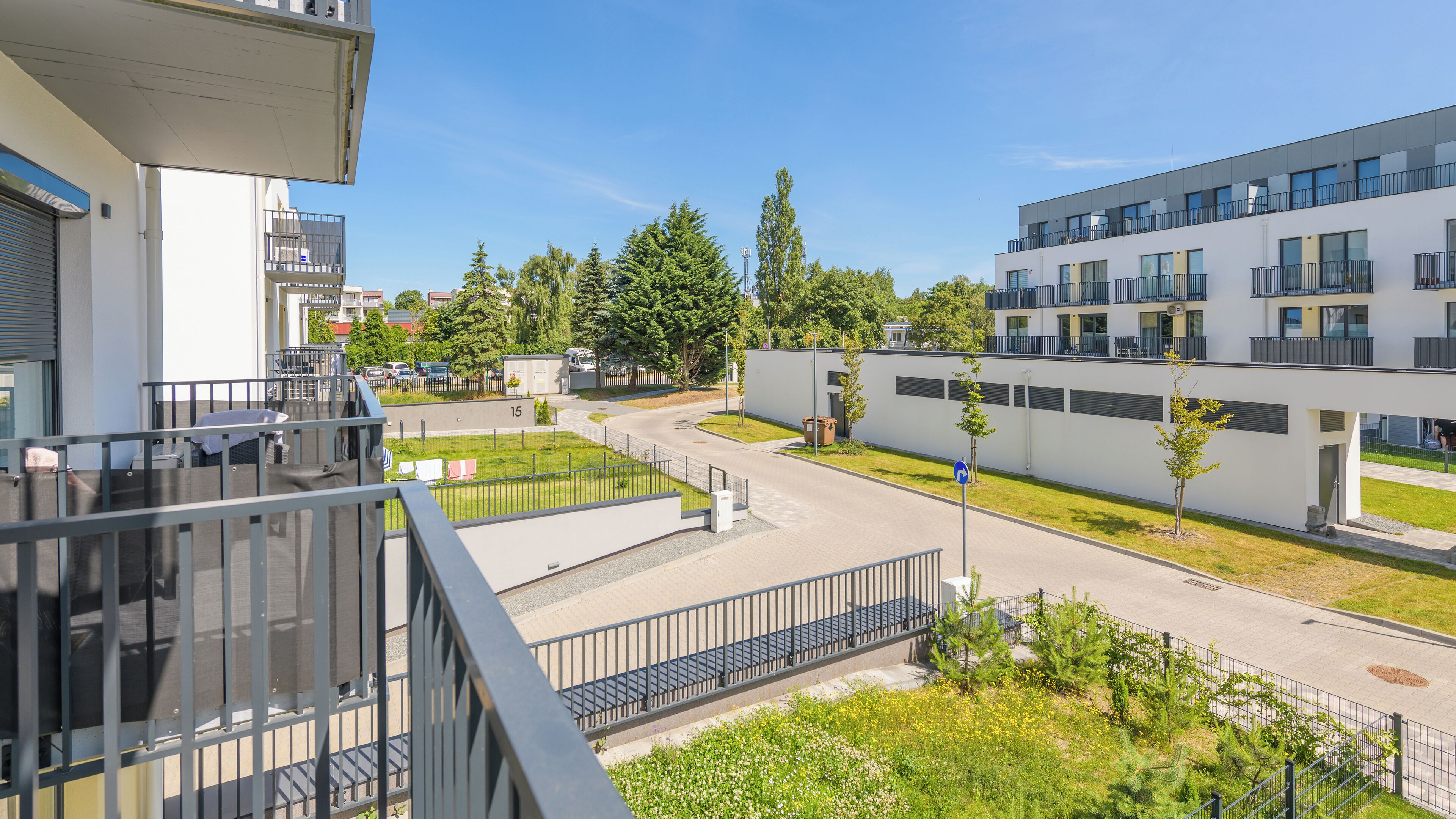 Moderni rakennus, jossa on tasakatto, suuret ikkunat ja parveke.