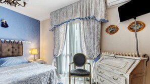 A bedroom with a bed, a chair, a dresser, and curtains.