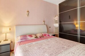 A bedroom with a bed, bedside tables, a lamp, and a wardrobe.
