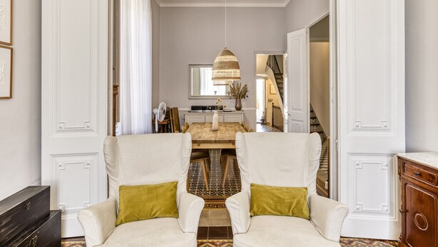 A hallway with a dining area, a staircase, and a view of the living room. - Modernist Manor House for 14 – 7 Bedrooms – Central Palafrugell – Patio – Garage (Palafrugell)