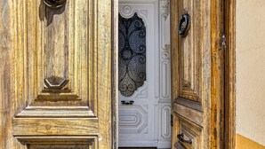 A wooden door with intricate carvings and a white door with a decorative glass panel. - Modernist Manor House for 14 – 7 Bedrooms – Central Palafrugell – Patio – Garage (Palafrugell)