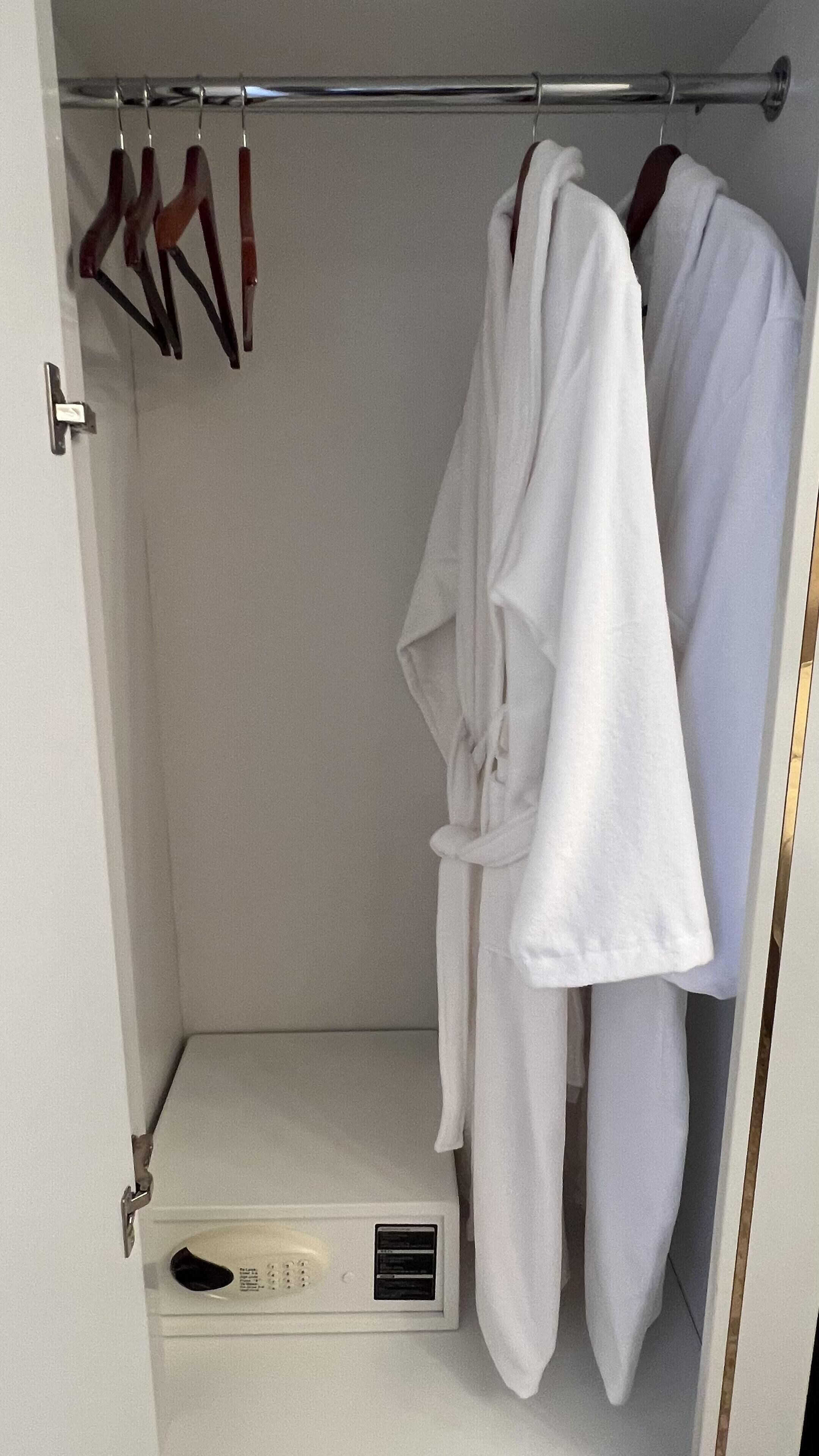 A walk-in closet with a hanging rod and a built-in dryer.