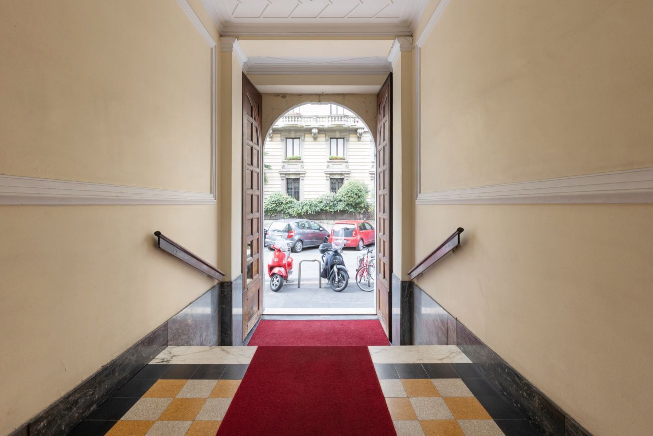 Ein Hotel Eingang mit einem roten Teppich, der zu einem Parkplatz führt.