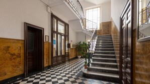A lobby with a checkered floor, a staircase, and wooden paneling. - Splendid two-room apartment Dateo - Mirable PM (Milano)