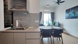 A modern kitchen with a built-in sink, a ceiling fan, and a dining area with a table and chairs. - The Grand Subang Jaya SS15 By Emily in Town (Subang Jaya)