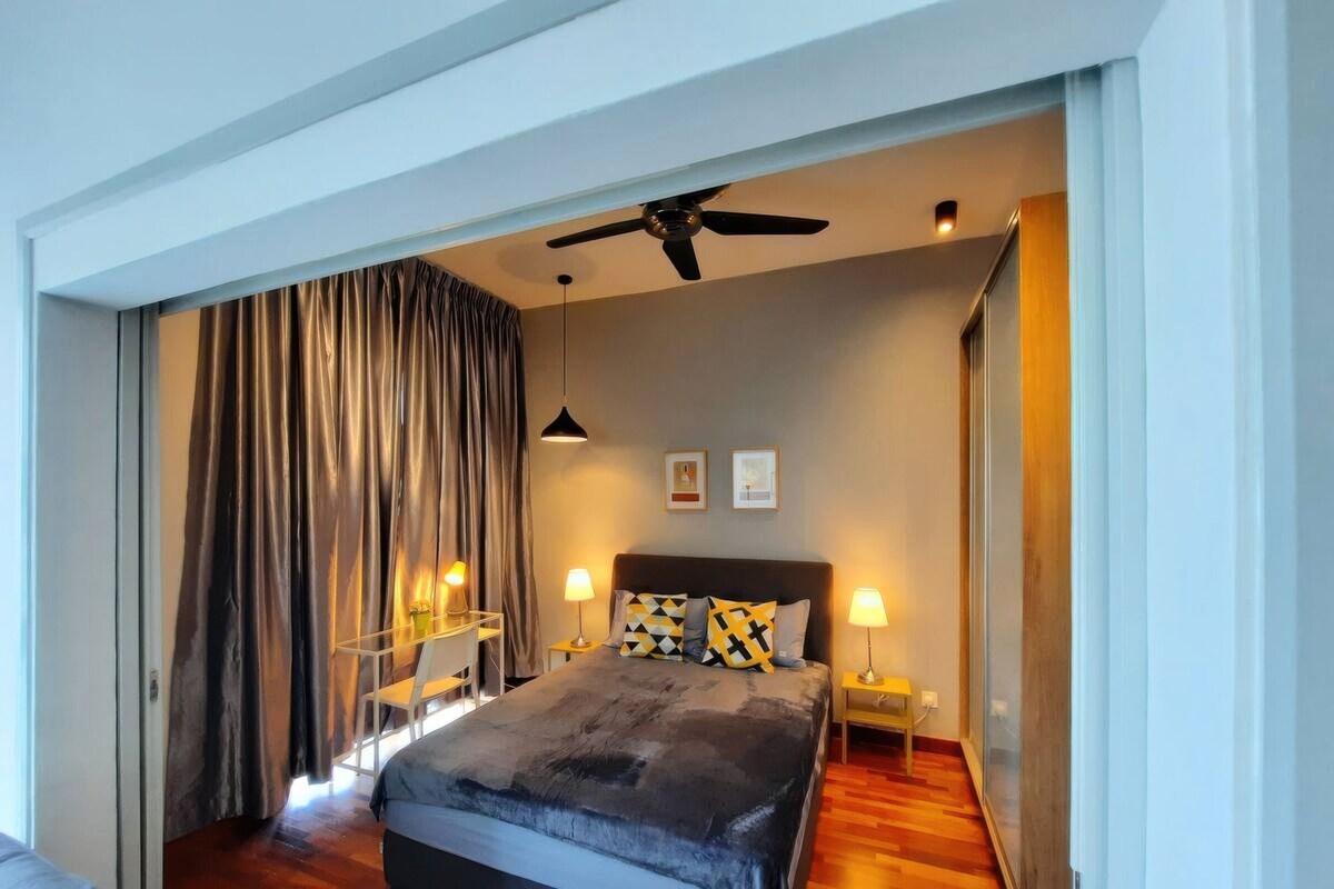 Un dormitorio moderno con una cama grande, ventilador de techo y vistas al exterior.