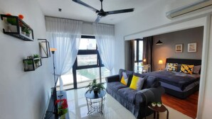Une chambre d’hôtel moderne équipée d’un lit, d’un canapé, d’une petite table et d’un ventilateur de plafond.