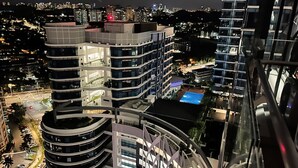 Un immeuble de grande hauteur, doté de nombreux étages, de grandes fenêtres et d’une piscine sur le toit.