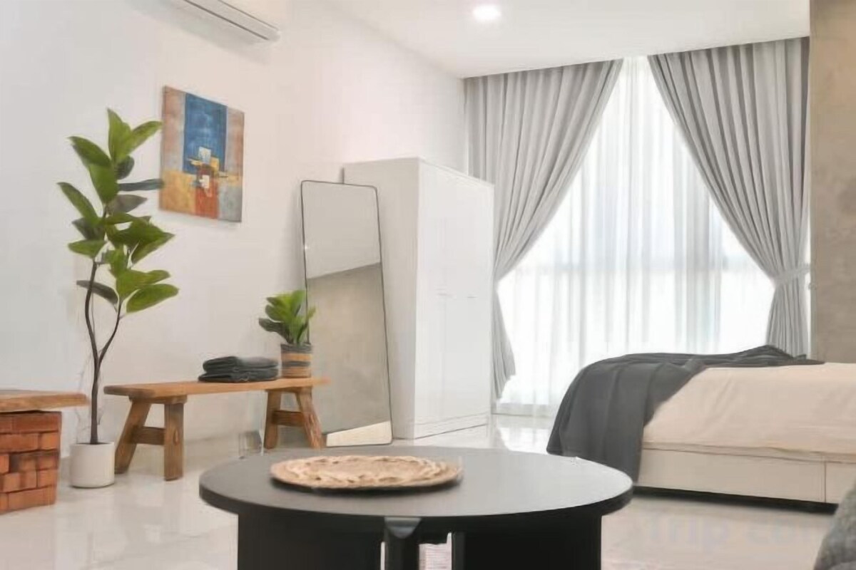 Une chambre à coucher moderne avec un lit, une table de chevet, un miroir, une plante en pot et une fenêtre avec des rideaux.